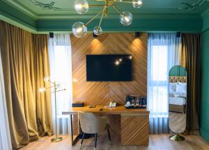 萨图马雷HOTEL VIENA的一间房间,配有一张桌子和一台墙上的电视