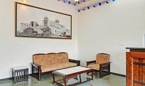 乌代浦Treebo Trend Khakhri Haveli的客厅配有沙发和两把椅子