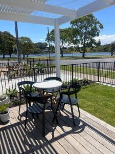 莱克斯恩特伦斯Quarterdeck Lakes Entrance 2br *Waterfront* Apartment的露台设有桌椅