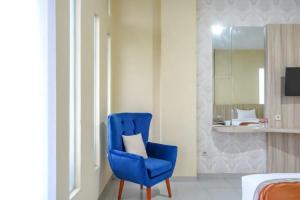玛琅De Malang Sweet Homestay Syariah Mitra RedDoorz的卧室里配有带白色枕头的蓝色椅子