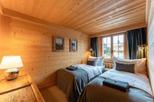 格施塔德Charming Alpine Apartment Gstaad的木墙客房的两张床