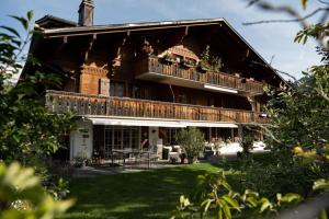 格施塔德Charming Alpine Apartment Gstaad的带阳台和桌子的大房子