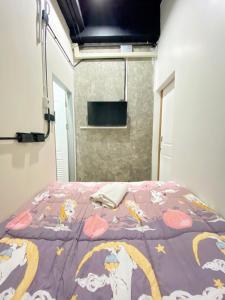 素叻Sleepbox Hostel Suratthani的一间卧室配有一张带紫色棉被的床