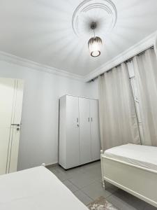 杰尔吉斯Residance saji的一间白色卧室,配有两张床和吊灯