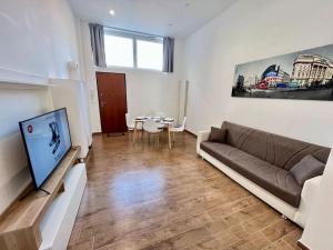 都灵Pregevole loft con soppalco的带沙发、电视和桌子的客厅