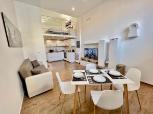都灵Pregevole loft con soppalco的用餐室以及带桌椅的起居室。