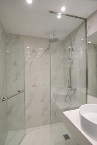雅典International Atene hotel的一间带玻璃淋浴和水槽的浴室
