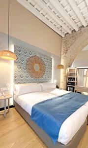 加的斯Soho Boutique Cádiz的一间卧室配有一张带蓝色毯子的大床