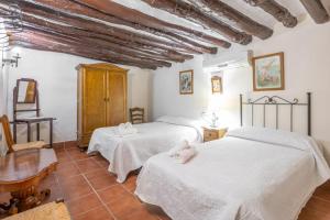 TebaMolino de Lucero, casa rural的一间卧室配有两张床和一张桌子。