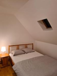 米奥修德萨斯Tiny house Floare de colt的一间卧室配有一张床和一张带台灯的桌子