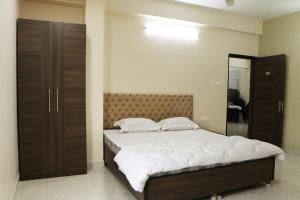 加尔各答Radharani Apartment的一间卧室配有一张大床和镜子