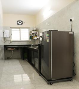 加尔各答Radharani Apartment的厨房配有不锈钢冰箱和台面