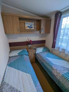 韦茅斯Caravan Littlesea Haven Weymouth Amazing Views的小型客房 - 带2张床和窗户