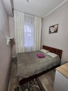 阿拉木图Оазис的一间小卧室,配有床和窗户