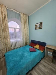 阿拉木图Оазис的一间卧室设有蓝色的床和窗户。