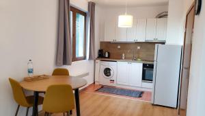 波罗维茨Semiramida Gardens Apartments的厨房配有桌子和白色冰箱。