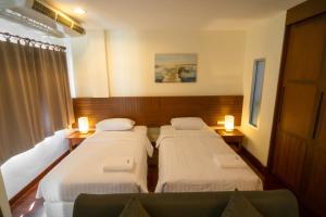 芭堤雅市中心Baan Chuan Chom Pattaya的酒店客房设有三张床和窗户。