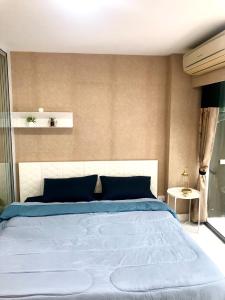 Ban Khlong SamrongBitec Bts Bangna New Luxury room的一间卧室配有一张带蓝色枕头的大床