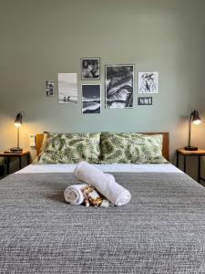 阿拉亚尔-杜卡布A Coroa Hostel & Suites的一张带毛巾和墙上照片的床