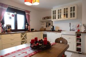 赛特朵夫Knusperhäuschen的厨房配有白色橱柜和红色蜡烛台