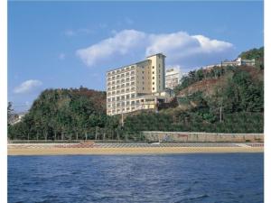 蒲郡市Hotel Mikawa Kaiyoukaku - Vacation STAY 90625v的一座大建筑,位于水边的山顶上