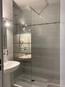 圣马迪拉莫阿卡兹酒店的一间带玻璃淋浴和水槽的浴室