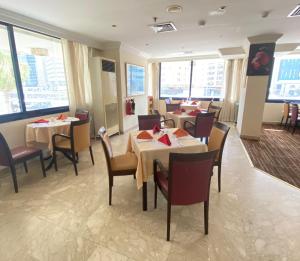 阿布扎比阿尔迪阿米娜酒店的用餐室设有桌椅和窗户。
