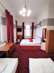 VojkoviceSherwood Hotel Vojkovice nad Ohří的酒店客房配有两张床和一张书桌