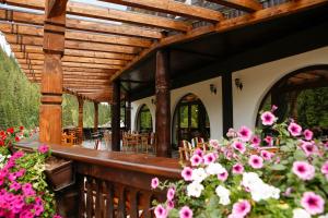 丰杜摩尔多瓦Casa Baciu Colacu的木甲板上配有桌椅和鲜花