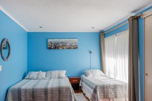 拉塞雷纳Apart Hotel Colors的蓝色的客房设有两张床和窗户。