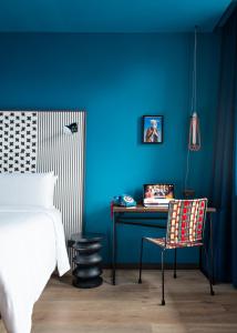 斯特拉斯堡BOMA easy living hotel的一间卧室设有蓝色的墙壁、桌子和椅子