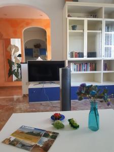 切奇纳L'isola felice的客厅配有带花瓶的桌子