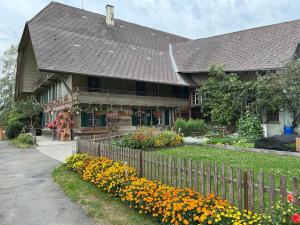 SumiswaldSchöne Ferienwohnung mit Hotpot und Sauna的前面有围栏和鲜花的房子