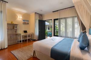 湄南海滩Sea&Sky Beach Resort的一间卧室配有一张床、一张书桌和窗户。