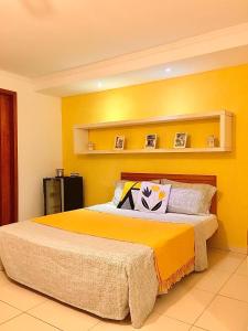 帕拉蒂Cantinho da Bruxa的一间卧室设有一张黄色墙壁的大床