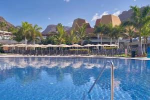 莫甘海滩大加那利莫干山雷迪森蓝光温泉度假酒店的一个带遮阳伞的游泳池和一个度假村