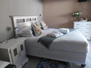 东伦敦Recoupe的卧室配有白色的床和白色梳妆台