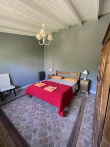 卡尔韦Casitas El Lago的一间卧室配有一张带红色毯子的床