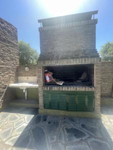 卡尔韦Casitas El Lago的庭院中设有砖砌壁炉及绿门