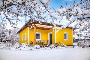 萨尔茨堡Ferienhaus Schlagerbauer Biohof的一座黄色的房子,地面上积雪