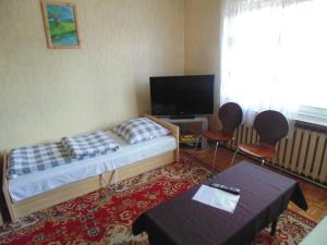比亚韦斯托克Villa Turysta的一间卧室配有一张床、两把椅子和电视
