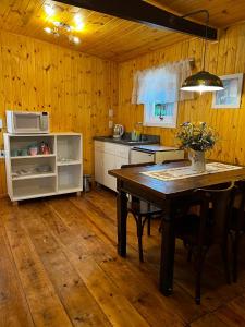 格拉玛多Apartamento Foss的厨房铺有木地板,配有桌椅。