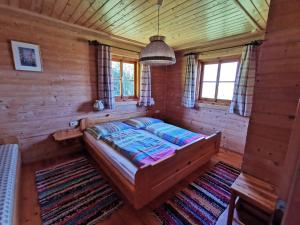 PatriasdorfFerienhaus Moosstadel的小木屋内一间卧室,配有一张床