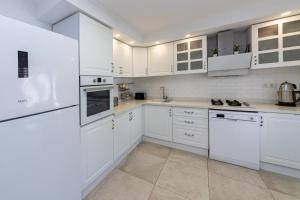 古穆斯卢克Amazing Duplex House with Sea View in Bodrum的白色的厨房配有白色家电和白色橱柜