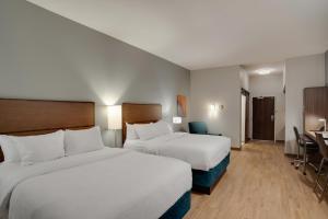 卡莱尔MainStay Suites Carlisle - Harrisburg的酒店客房配有两张床和一张书桌