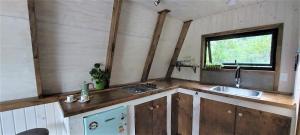 MolcoMolco Alpina的厨房配有木制橱柜、水槽和窗户。