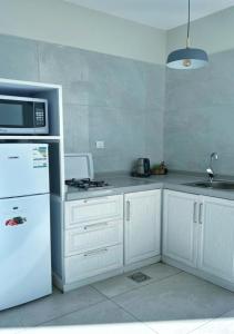 Al Qarāḩīnبيات للنزل السياحية的厨房配有白色冰箱和微波炉