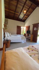 佩德拉斯港POUSADA RANCHO PARAISO的酒店客房设有两张床和电视。
