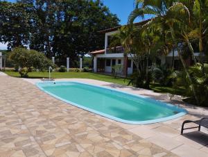 科曼达图巴岛Pousada São Nunca的一座带房子的庭院内的游泳池