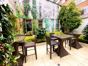 波哥大Hotel Marbella Chico的户外庭院设有桌椅和植物